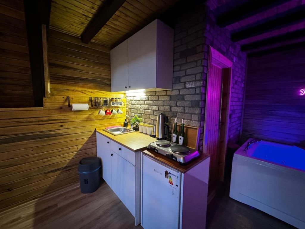 a kitchen with a counter with purple lights on it at Adalar Garden Bungalov in Kartepe