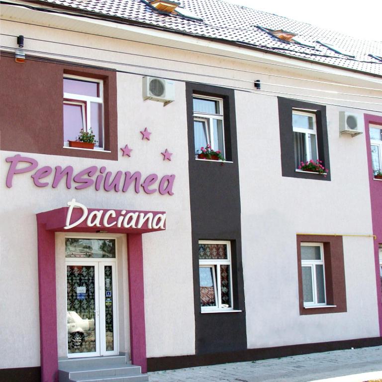 a building with a sign on the side of it at Pension Daciana in Bacău