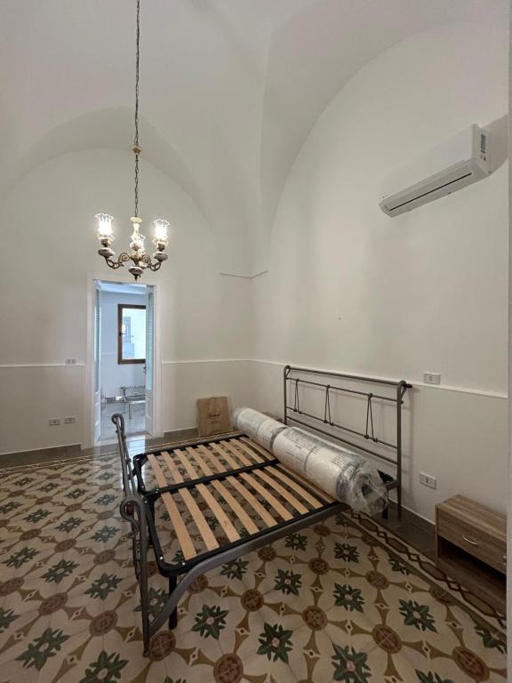 Zimmer mit einem Bett und einem Kronleuchter in der Unterkunft Casa vacanza Salento in Aradeo