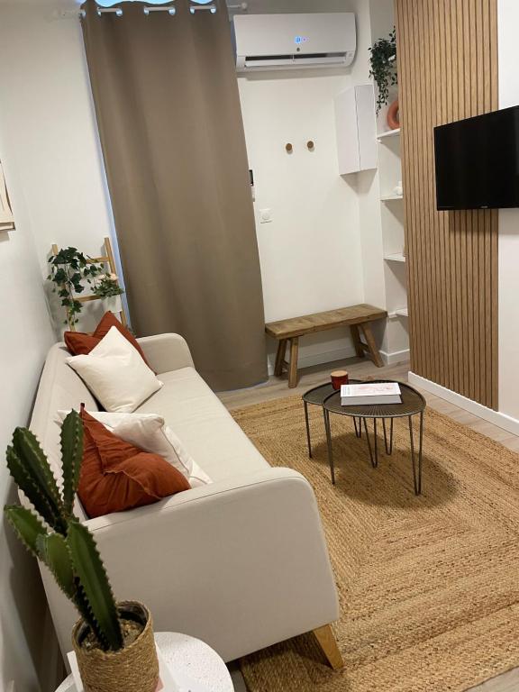 a living room with a white couch and a table at - Le Gambetta - in Moulins