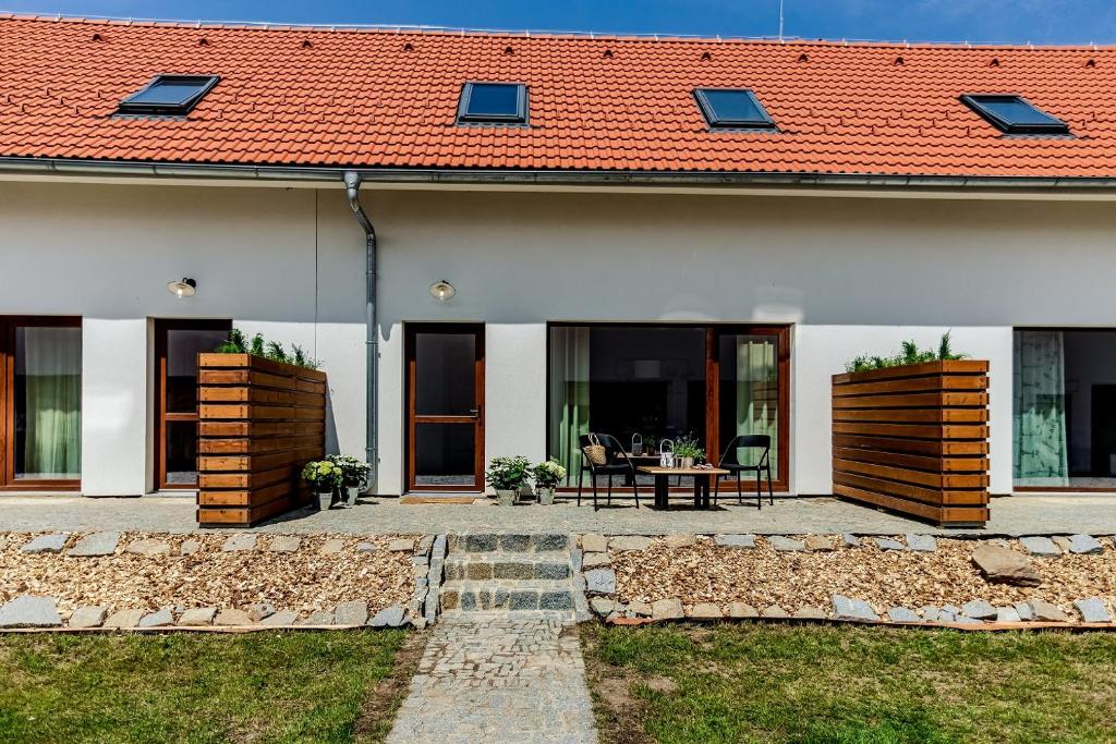 ein Haus mit einem roten Dach und einer Terrasse in der Unterkunft Apartmány Branná 31 Třeboň in Třeboň