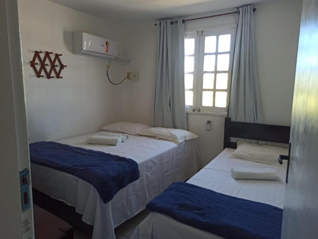 ポルト・デ・ガリーニャスにあるPrivê Recanto da Enseada - Serrambiの窓付きの部屋 ベッド2台