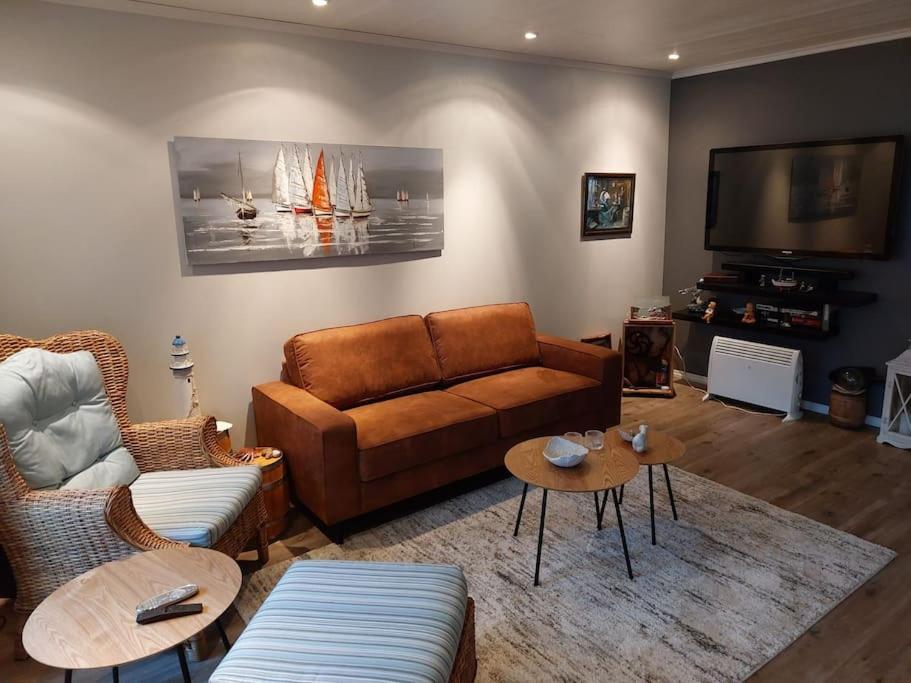 uma sala de estar com um sofá e uma televisão em Rorbu i Austevoll med 3 soverom og mulighet for båtleie em Kolbeinsvik