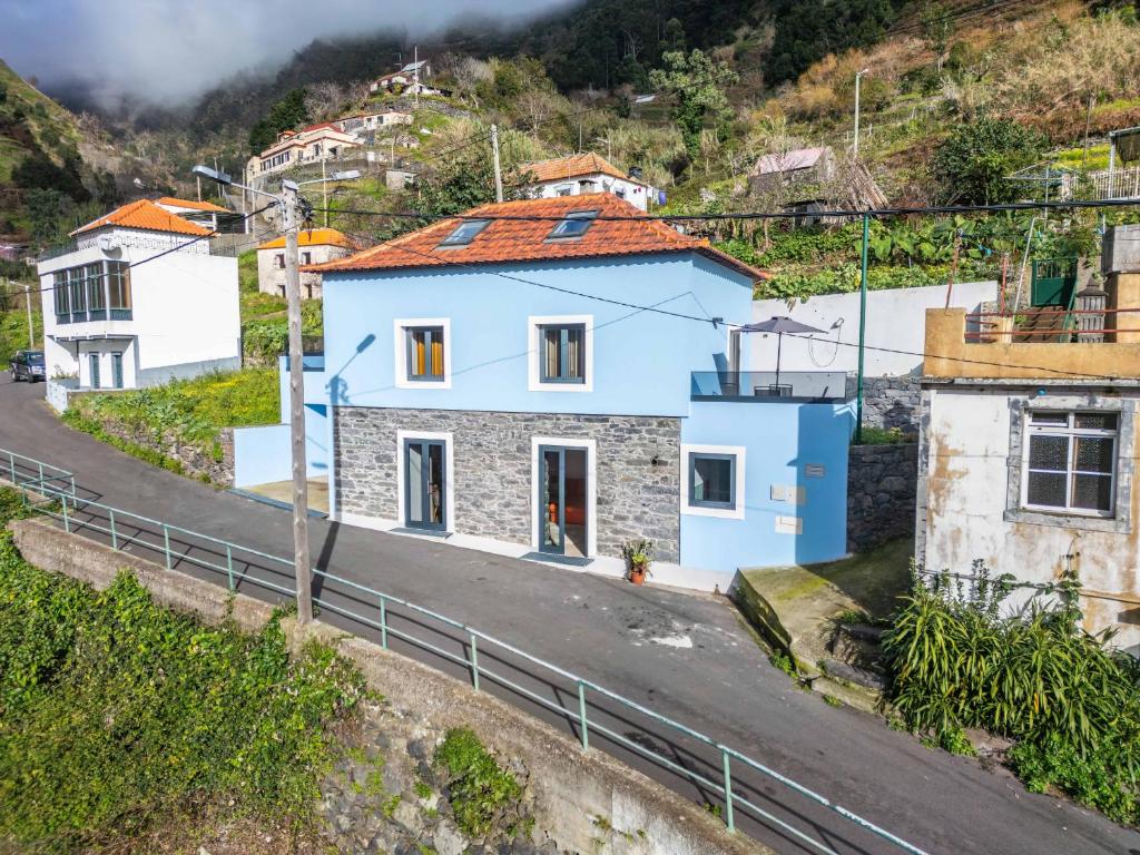 a blue house on the side of a road at AGUIAR´S VILLAGE in Ribeira Brava