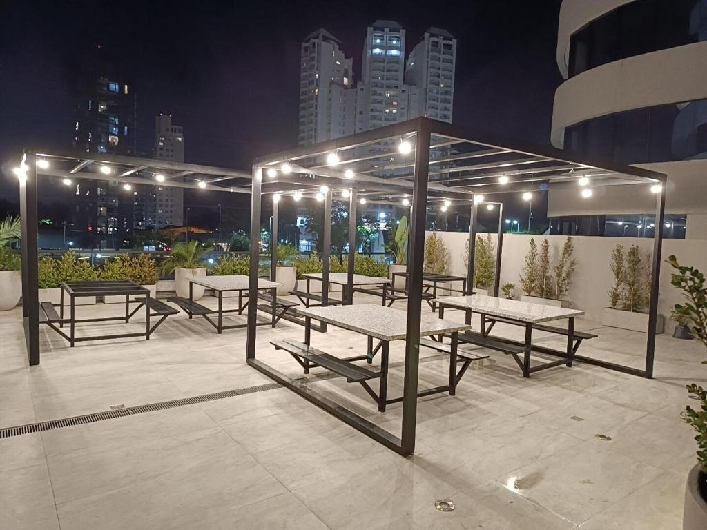 a group of picnic tables on a rooftop at night at Torres Brickell Plaza. in Tigre