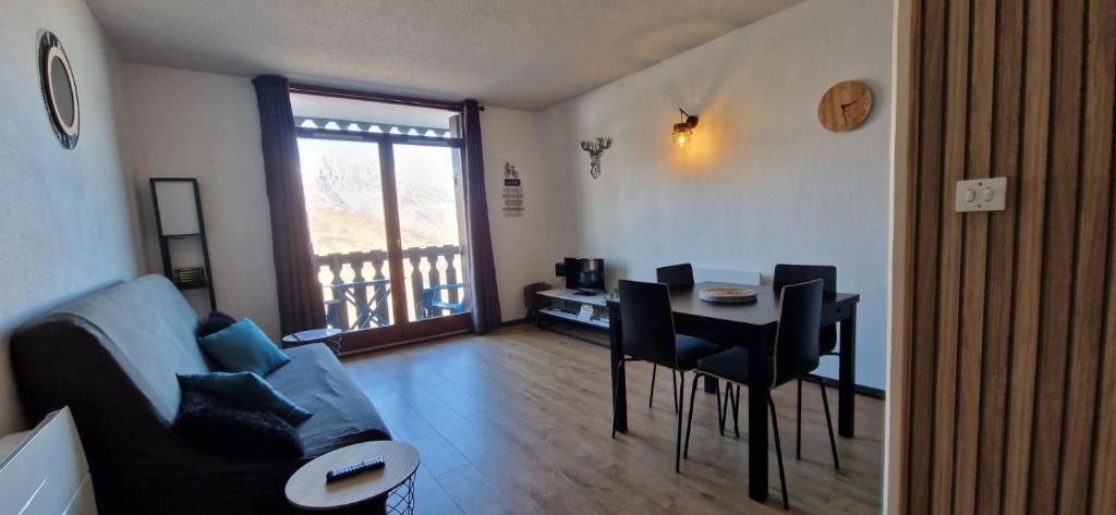 a living room with a couch and a table and chairs at Appartement Saint Lary - pla d'adet - aux pieds des pistes in Saint-Lary-Soulan