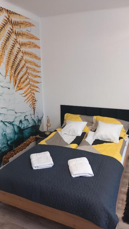 a bedroom with a bed with two towels on it at City Break Apartment Koszalin centrum in Koszalin