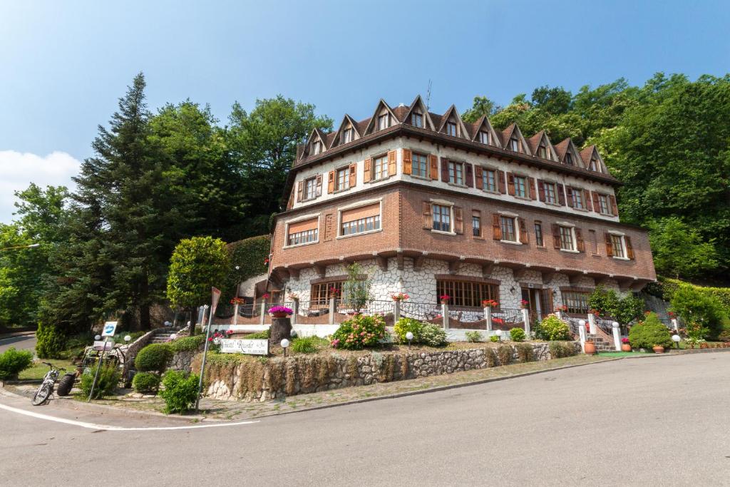 un grand bâtiment en briques sur le côté d'une rue dans l'établissement Hotel Ricordo Du Parc, à Tabiano