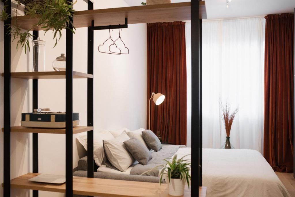 a room with a bed and a shelf with a couch at B/Loft in Prato