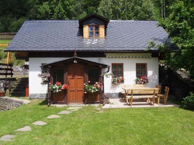 Casa pequeña con mesa y puerta de madera en Domeček Karlov en Malá Morávka