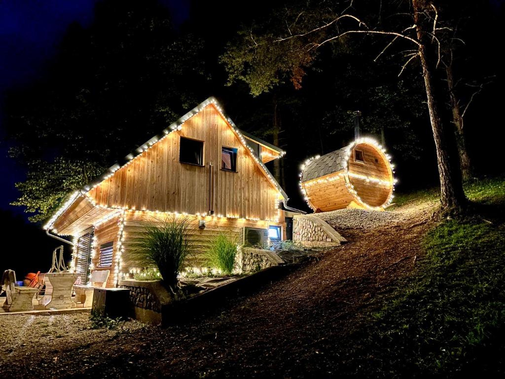 un granero con luces de noche. en Romantic cabin with hot/cold tub and finnish sauna en Šentvid pri Stični