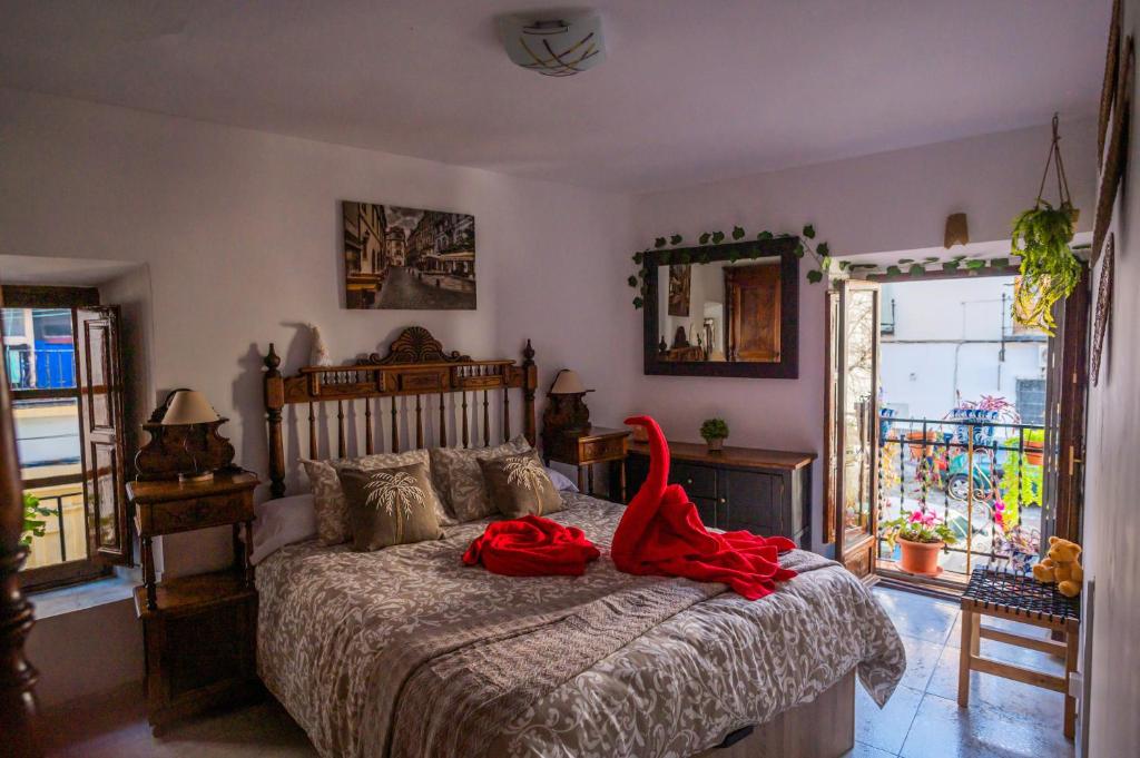 a bedroom with a bed with a red robe on it at Casa Asia in Granada