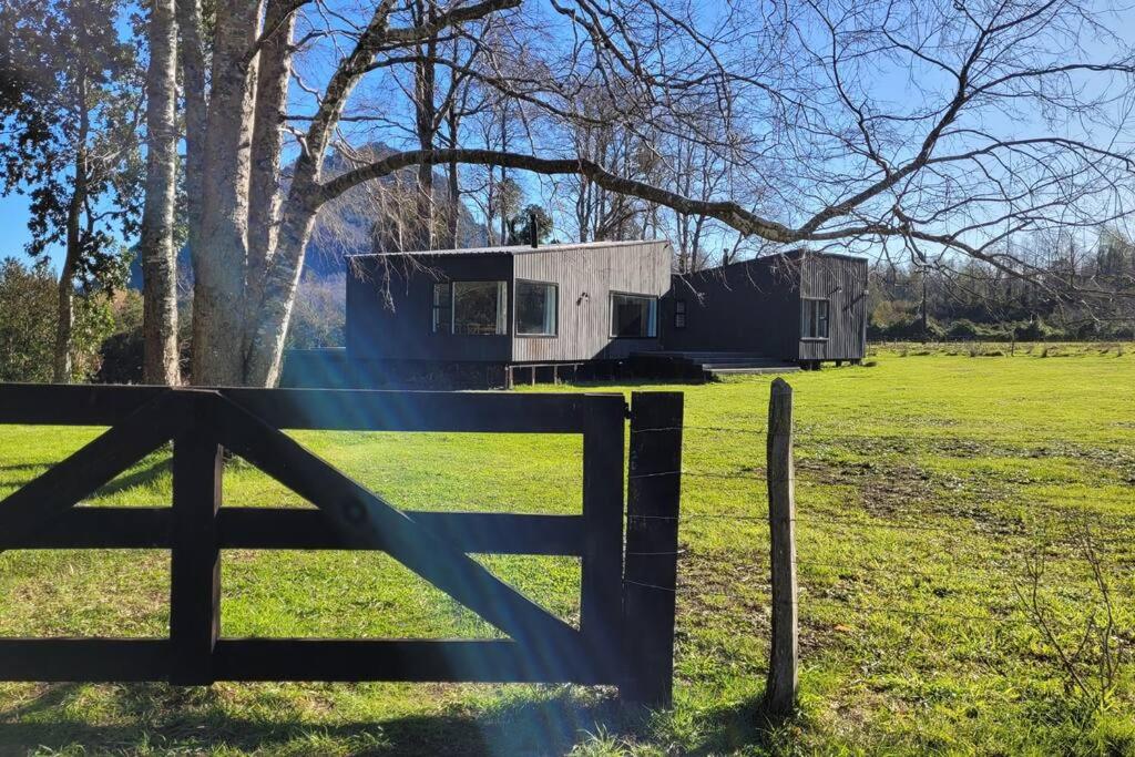 ein Haus auf einem Feld mit einem Zaun in der Unterkunft Casa de campo sobre el rio in llifen