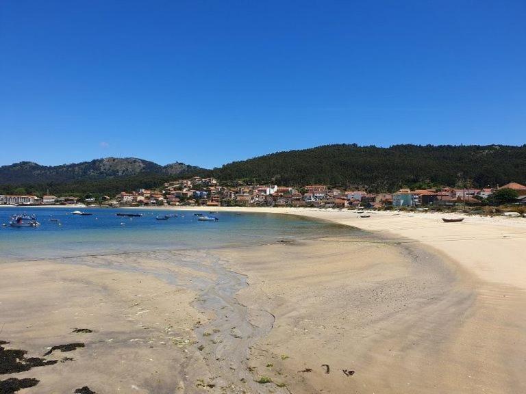 uma praia com um grupo de barcos na água em El rinconcito de Aldán em Aldán