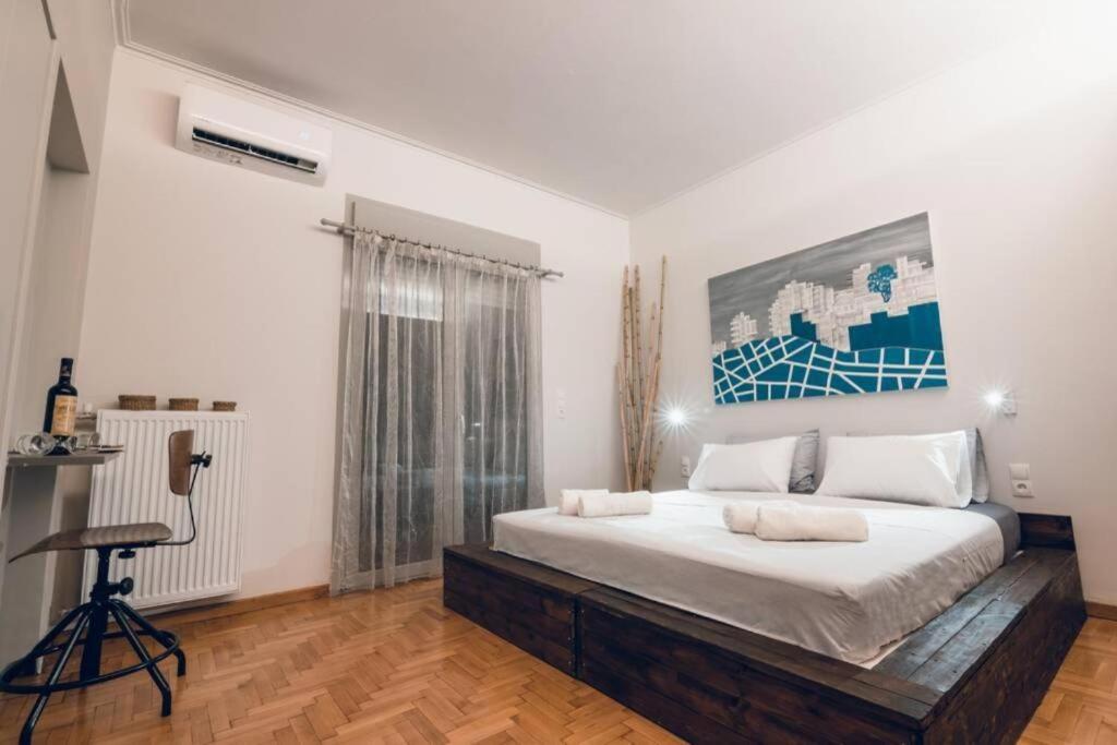 a bedroom with a large bed and a chair at Xenia's Cozy Apartment (near Acropolis Museum) in Athens