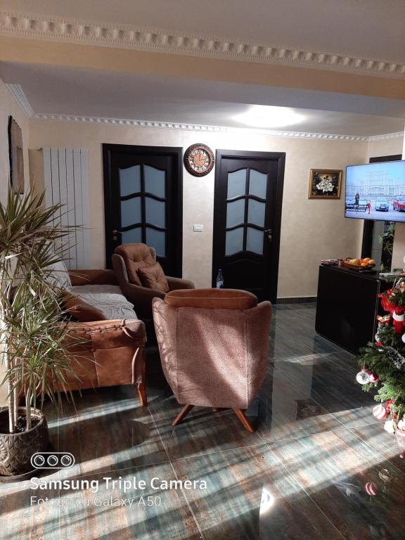 ein Wohnzimmer mit Sofas und einem Flachbild-TV in der Unterkunft Casa Nicolas Busteni in Buşteni