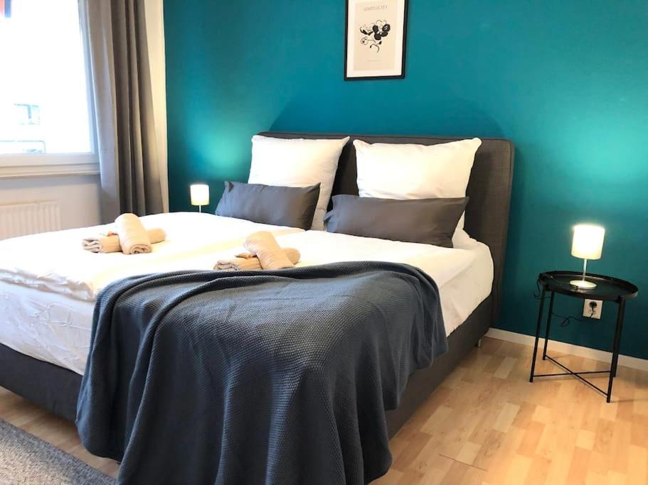 a bedroom with a large bed with two stuffed animals on it at LIME HOMES: Küche, Balkon, Netflix in Hildesheim