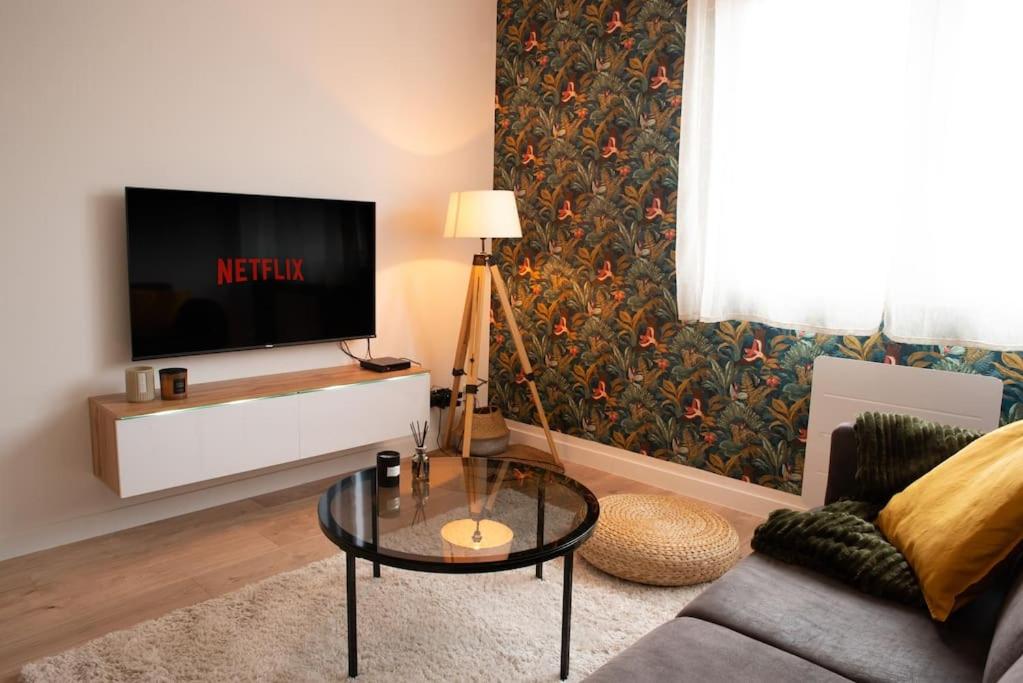 un salon avec une télévision et une table basse dans l'établissement Charmant T2 Rénové+Parking privé, à Aucamville