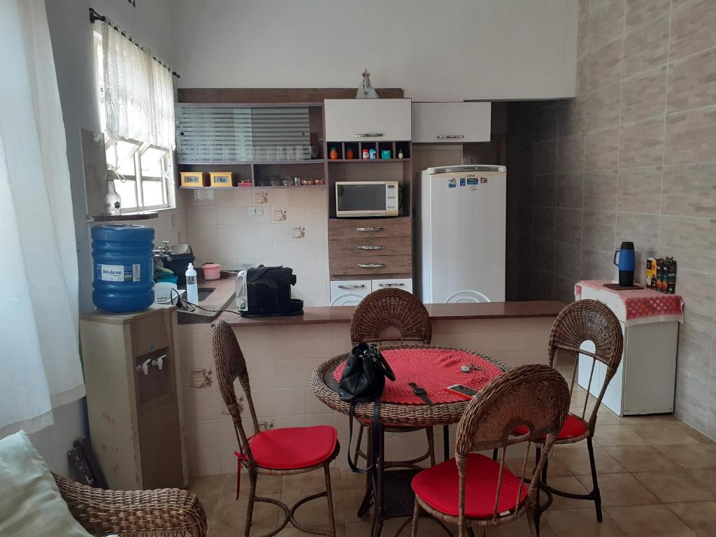 een keuken met een tafel en vier stoelen en een aanrecht bij Casa com boas acomodações in Itanhaém