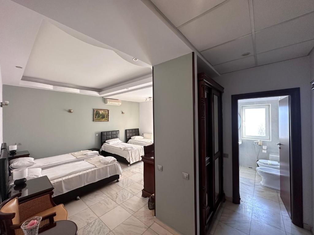 a room with three beds and a bathroom at Hotel Bliss in Bucharest