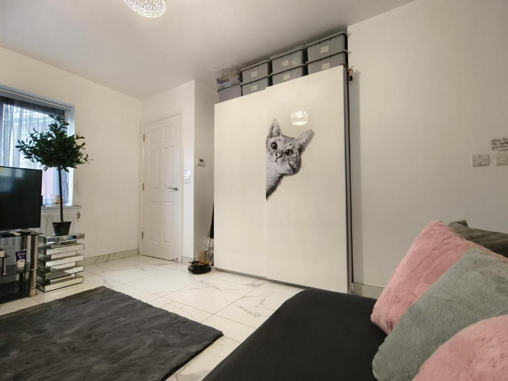 ein Wohnzimmer mit einem Bild einer Katze an der Wand in der Unterkunft Shared House - 10 mins from Piccadilly Station/Man Uni/O2 Apollo in Manchester