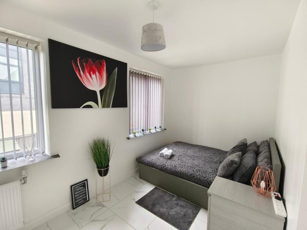 ein Schlafzimmer mit einem Sofa und einer roten Blume an der Wand in der Unterkunft Shared House - 10 mins from Piccadilly Station/Man Uni/O2 Apollo in Manchester
