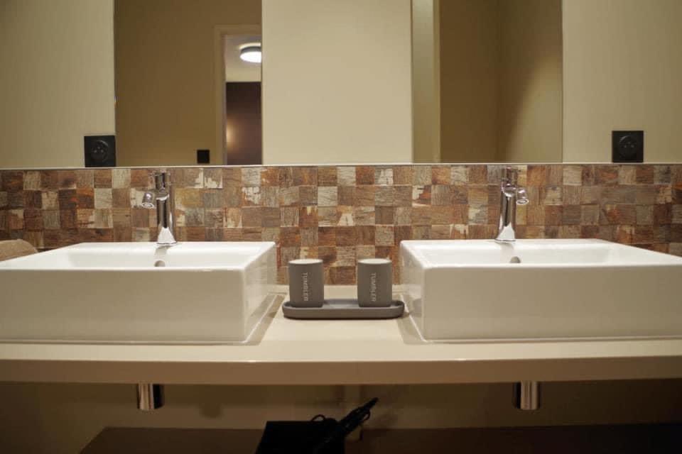 La salle de bains est pourvue de 2 lavabos blancs et d'un miroir. dans l'établissement Vigne en fleur, à Chaintré