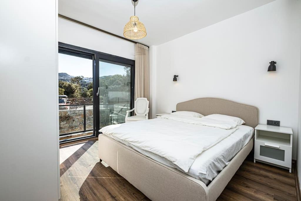 a bedroom with a bed and a large window at Villa Al Mare 2; Koyunbaba'da Özel Havuzlu Villa in Bodrum City