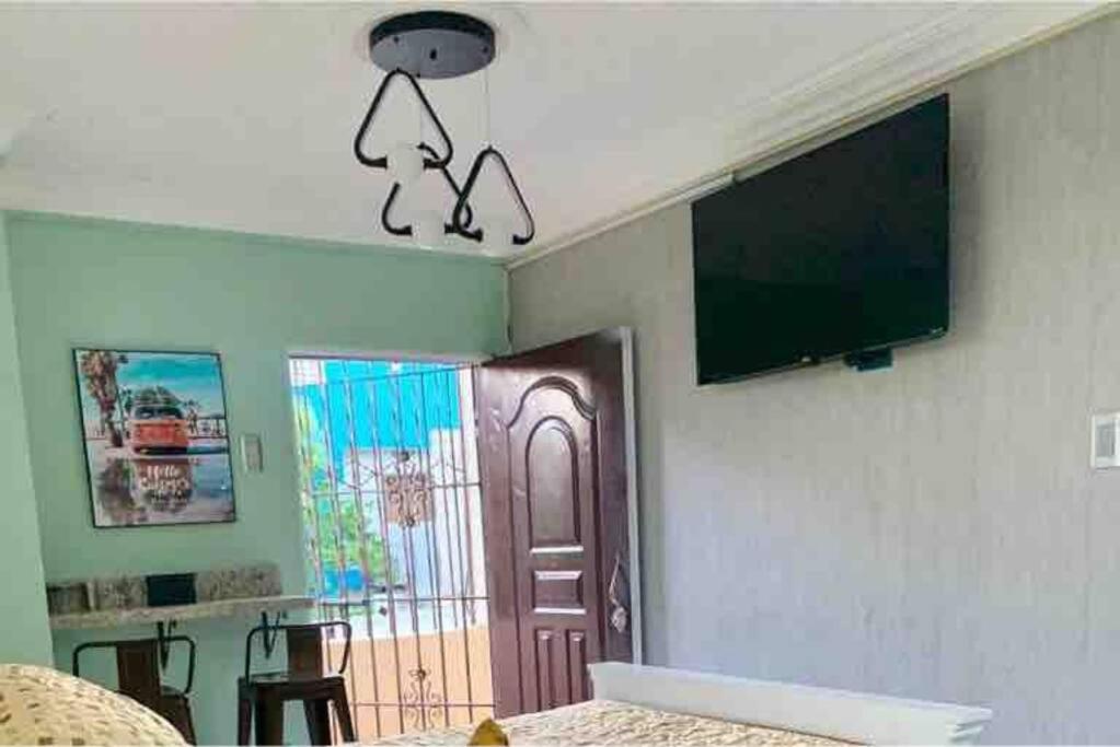 - une chambre avec une télévision suspendue au plafond dans l'établissement Apartaestudio Doña Rosa, à San Pedro de Macorís
