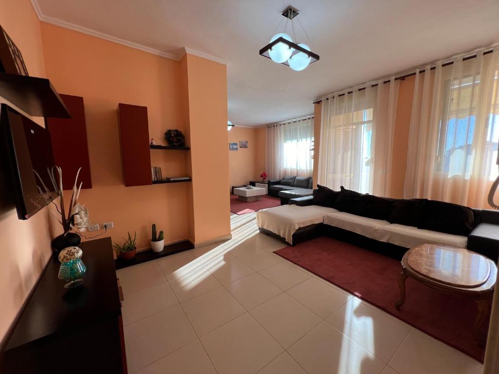 uma sala de estar com um sofá e uma mesa em Elbasan center family apartment n.42 em Elbasan