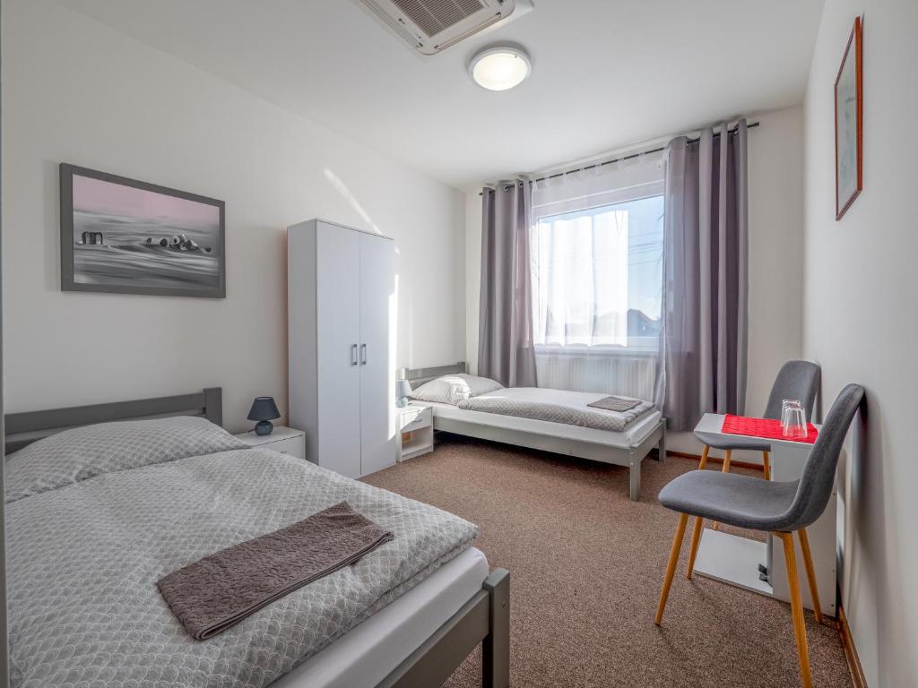 um quarto de hotel com duas camas e uma janela em Penzion ARIES em Nitra