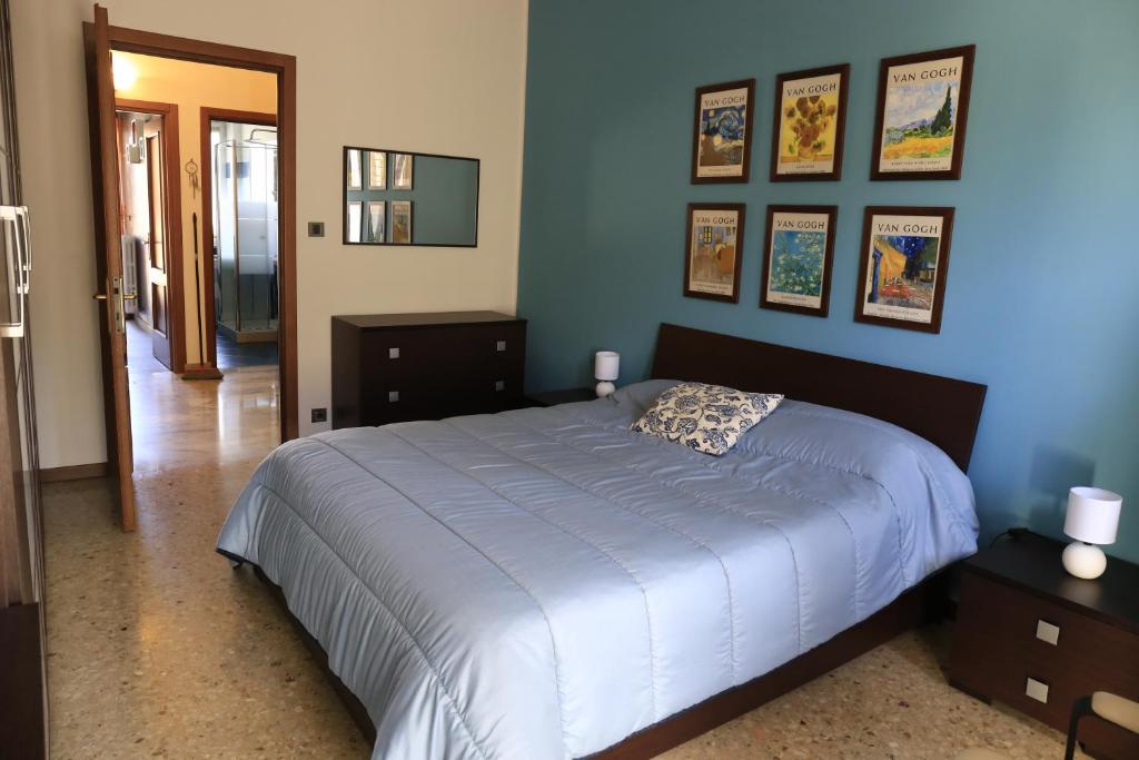 a bedroom with a large bed and pictures on the wall at Faber House in Venaria Reale