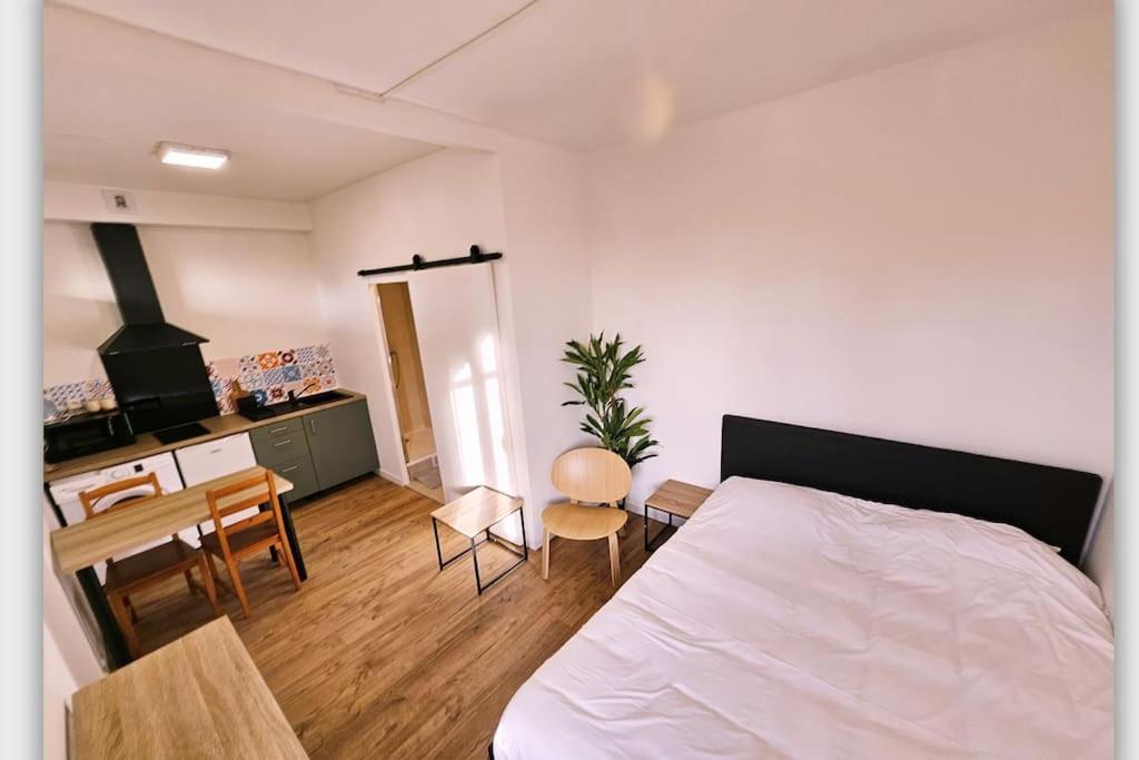 1 dormitorio con cama, mesa y cocina en NERO studio confort tt équipé!, en Villejuif