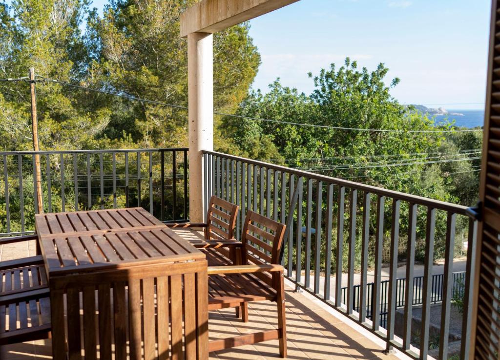 a porch with two chairs and a table on it at Chalet Font de Sa Cala in Font de Sa Cala
