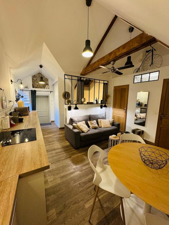 une cuisine et un salon avec un canapé et une table dans l'établissement Le Néo au 17, appartement cosy dans le centre historique de Rodez, à Rodez