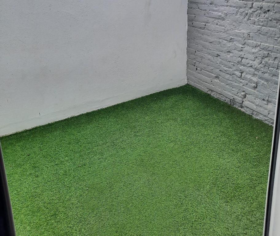 Pokój z zieloną trawą obok ściany z cegły w obiekcie Bonito Alojamiento F w Walencji