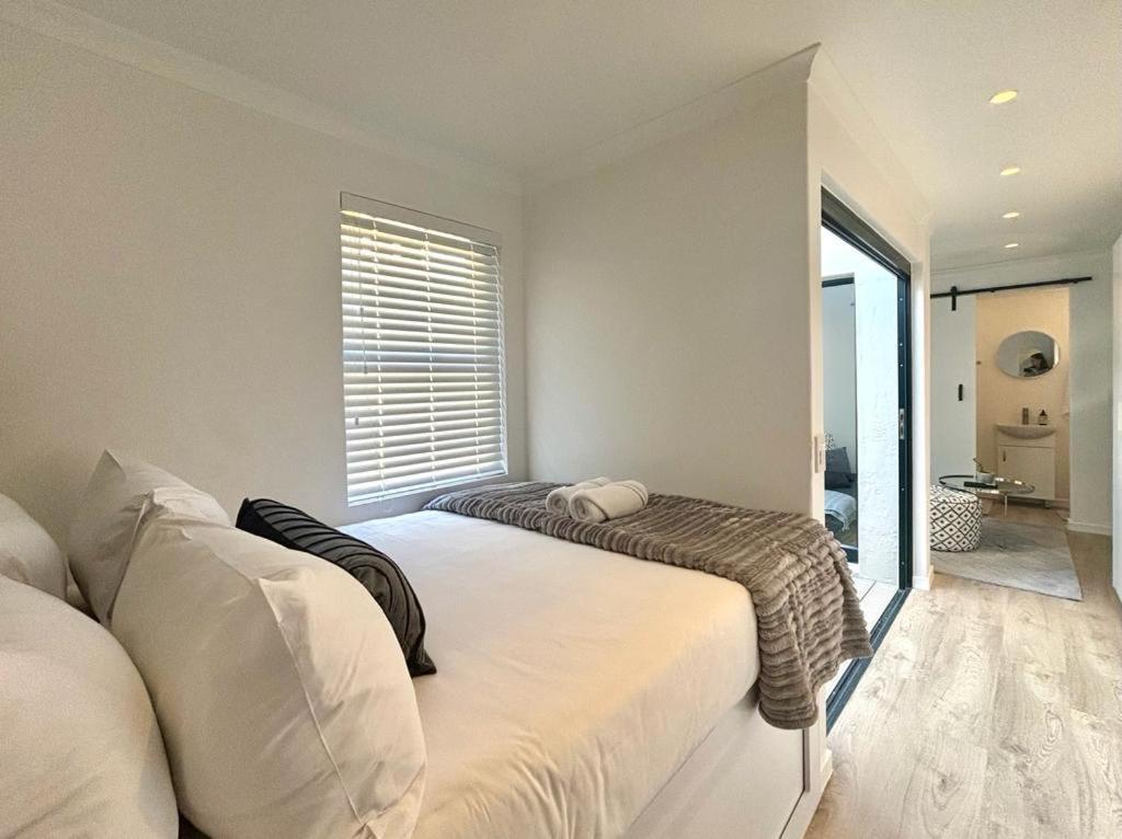 a bedroom with two beds and a window at The Saasveld in Cape Town