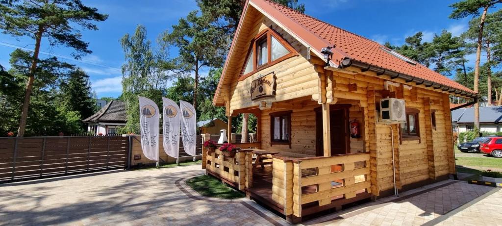 Cabaña de madera pequeña con valla y tablas de surf en Domek z Bala Pod Żaglami en Pobierowo