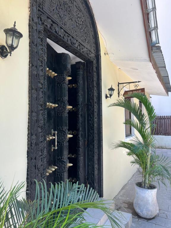 a door in the side of a building with a plant at Bin Omiar Malindi Apartment in Stone Town