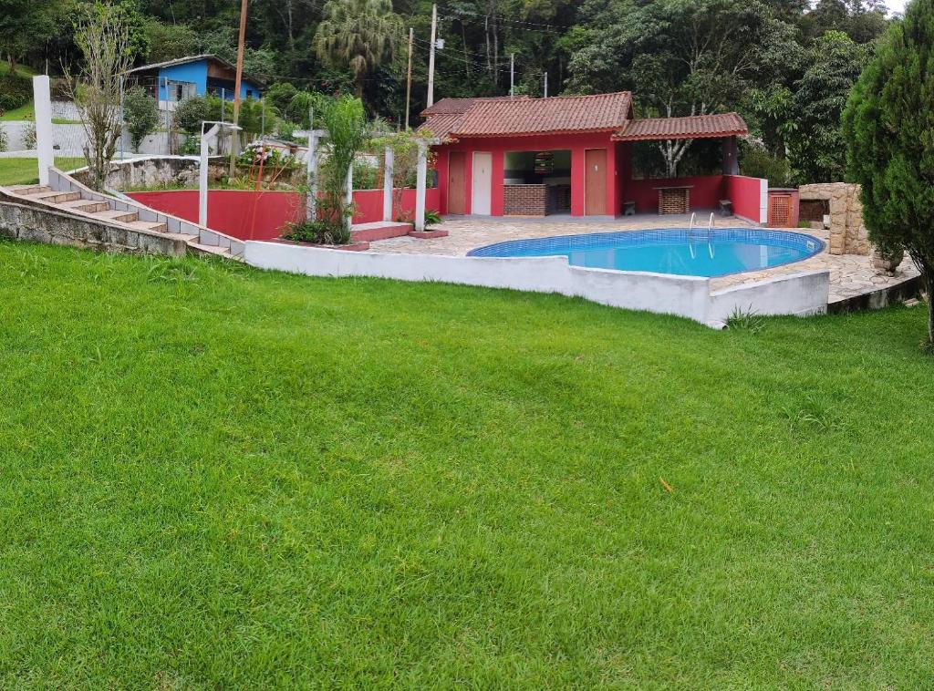 einen Hof mit einem Pool und einem Haus in der Unterkunft Chácara, 3 suítes, piscina, lago, wi-fi 250 mbps in Guarulhos