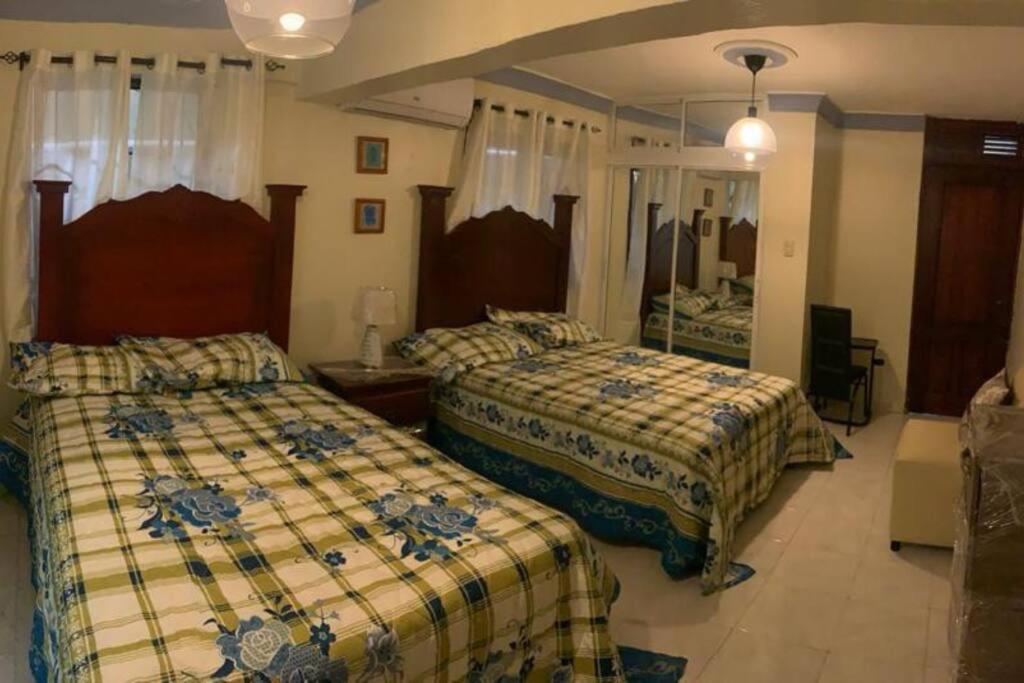 1 dormitorio con 2 camas y espejo en Apartment in San Pedro de Macoris., en San Pedro de Macorís