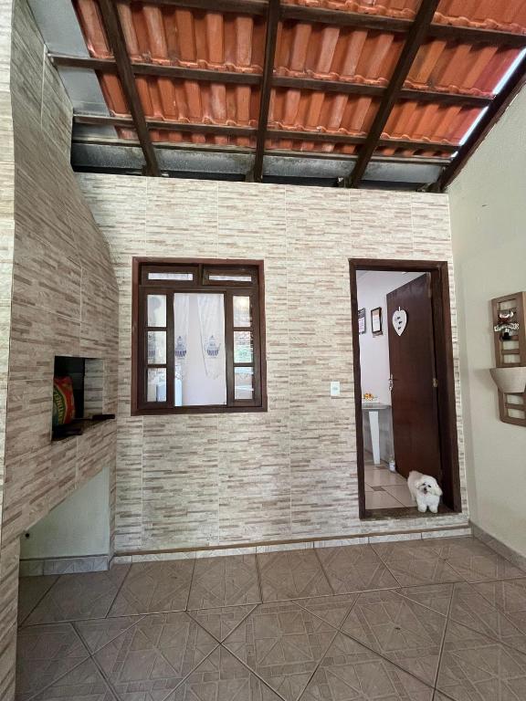 ein Zimmer mit zwei Fenstern und einem Hund auf dem Boden in der Unterkunft Casa com suíte in Blumenau