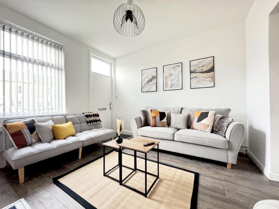 a living room with two couches and a table at Stylish home in York - Free Wifi & Parking - Close to Racecourse & City Centre in York