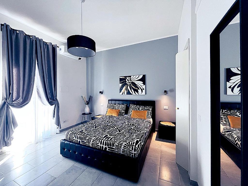 a bedroom with a black and white bed and a window at Pit stop Ciampino Station in Ciampino