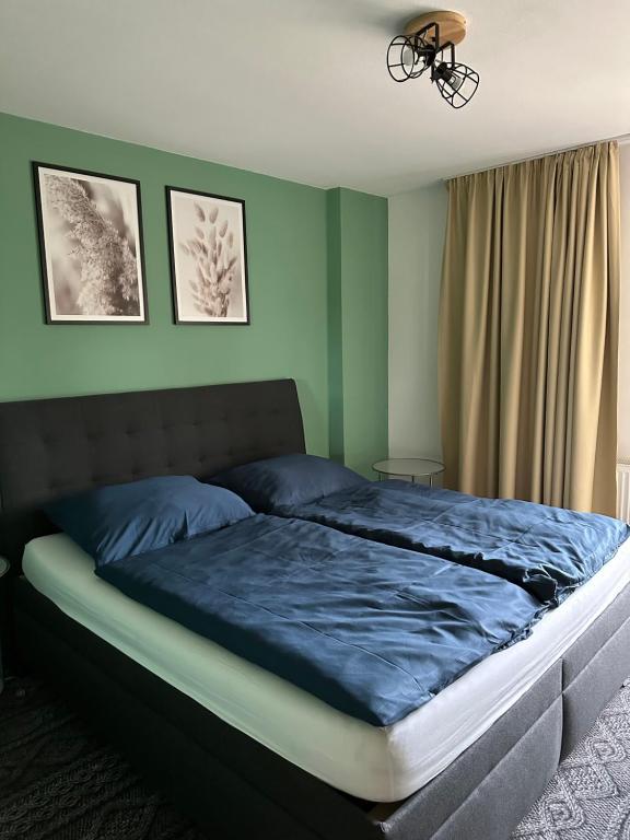 - une chambre dotée d'un grand lit avec des draps bleus dans l'établissement BART APARTMENTS Veľká Lomnica, à Veľká Lomnica
