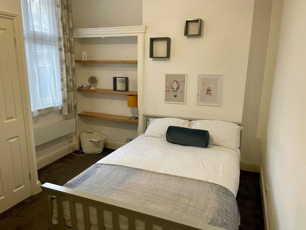 um quarto com uma cama com uma almofada verde em Self Contained 1 Bedroom Duplex em Leicester