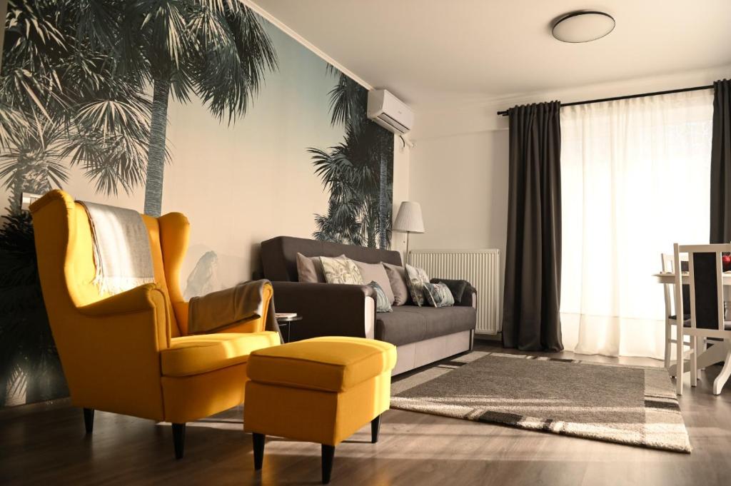 ein Wohnzimmer mit einem gelben Stuhl und einer Couch in der Unterkunft Mathias Airport Residences & Therme-Self Check-in in Otopeni