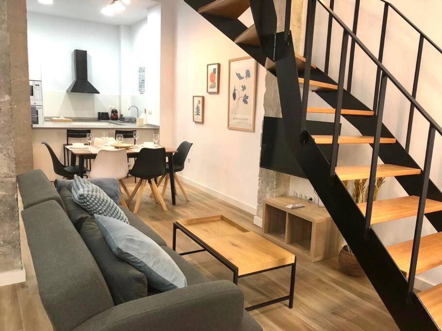 uma sala de estar com um sofá e uma escada em espiral em Duplex nueva construcción en Málaga-Centro em Málaga