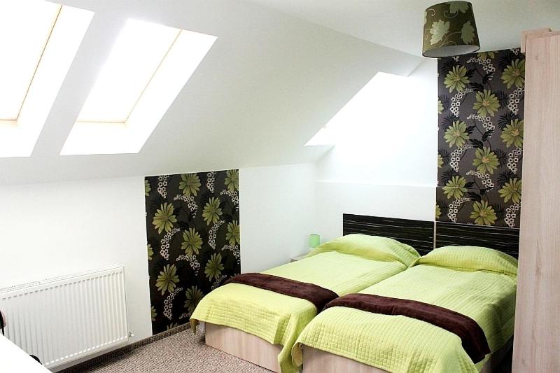 a bedroom with a bed with yellow sheets and a window at Pension Daciana in Bacău