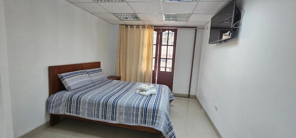 ein Schlafzimmer mit einem Bett mit einem ausgestopften Tier darauf in der Unterkunft HOTEL TICLIO in Cajamarca